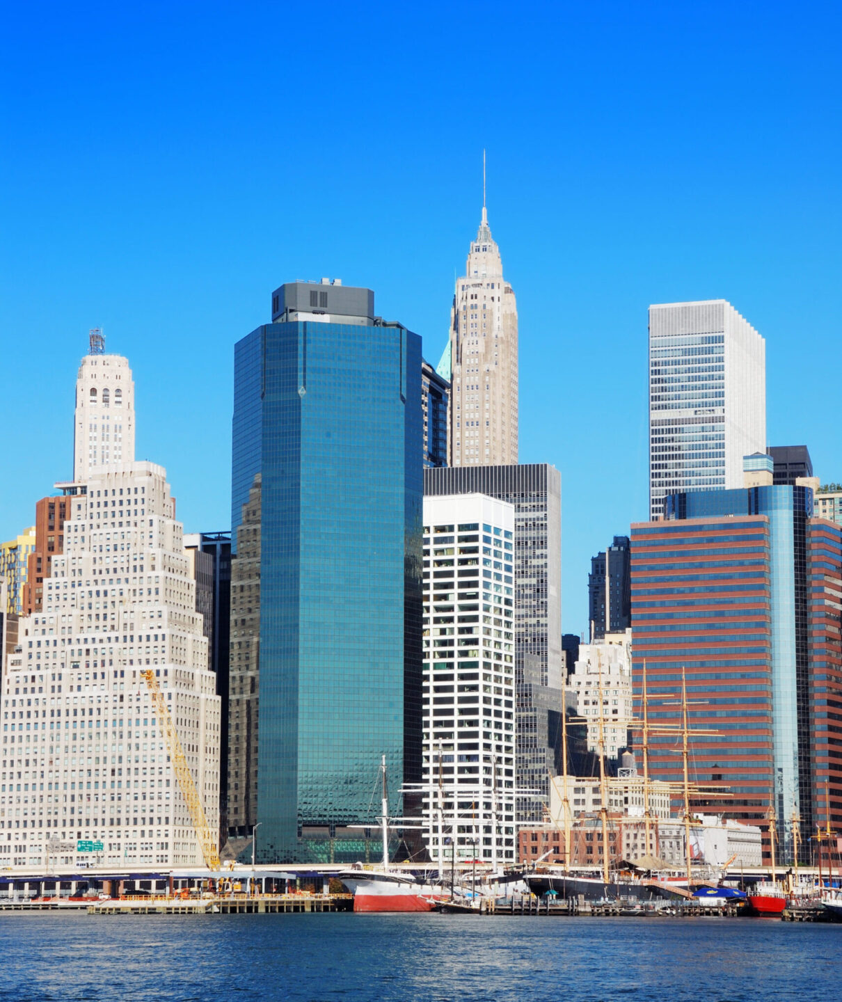 New York City Manhattan skyline panorama in the morning with skyscrapers over Hudson River with blue sky.
